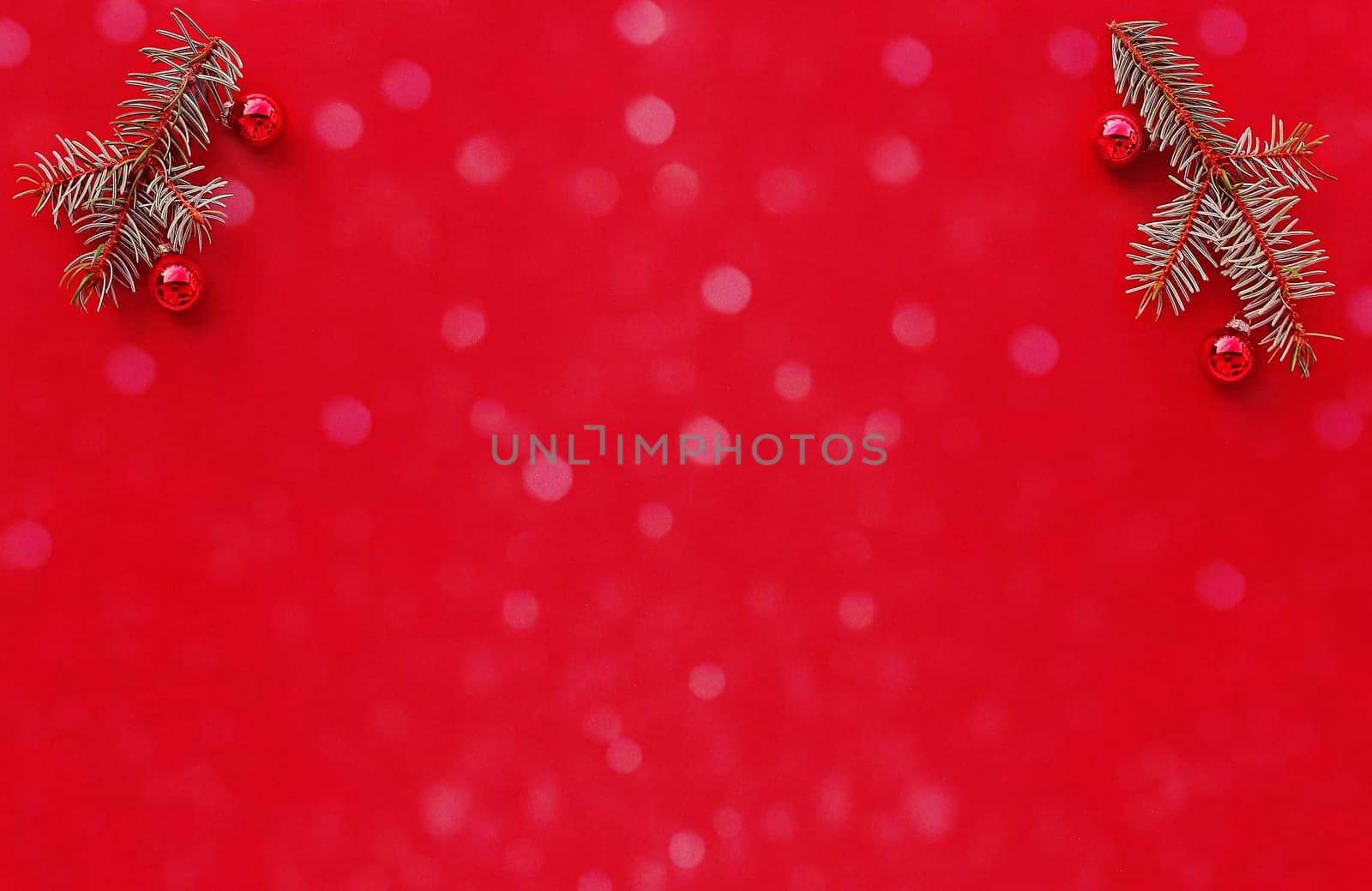Christmas red background with fir branches, Christmas tree baubles and snowflakes