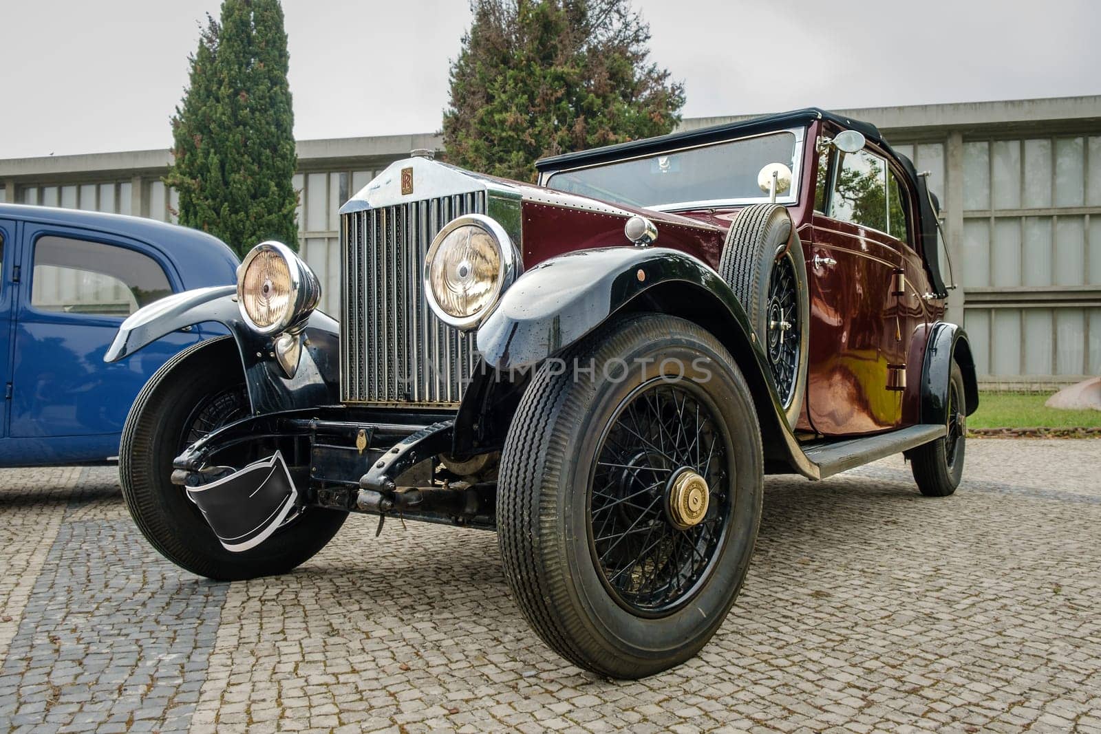 Lisbon, Portugal - Oct 15, 2023: Vintage and rare Rolls-Royce Twenty drophead car parked in driveway near building. Luxury 4-door convertible small car, 1920s, by Rolls-Royce Ltd, Britain, UK.