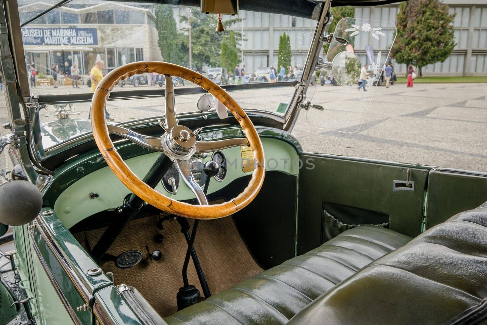 Lisbon, Portugal - Oct 15, 2023: Green interior with steering wheel and car dashboard of vintage Ford A Tudor Sedan. Wooden steering wheel and all-metal dashboard in selective focus.
