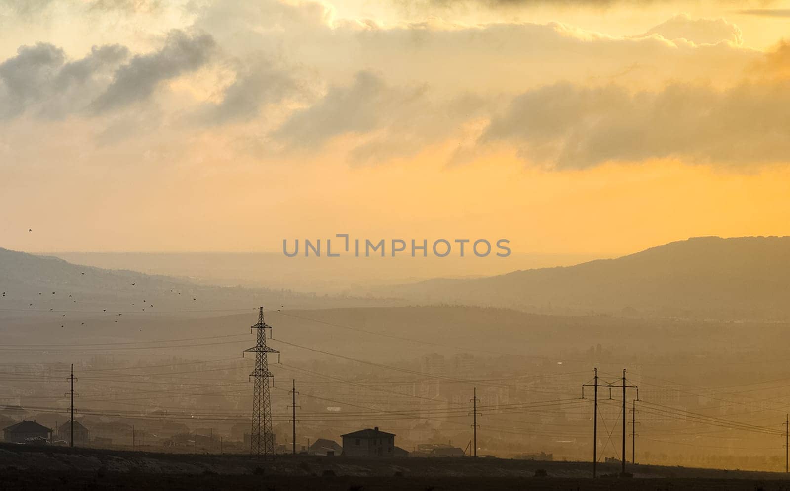 Dawn in the mountains of Crimea. A light haze of mist over the mountains and rays of the sun through the clouds.