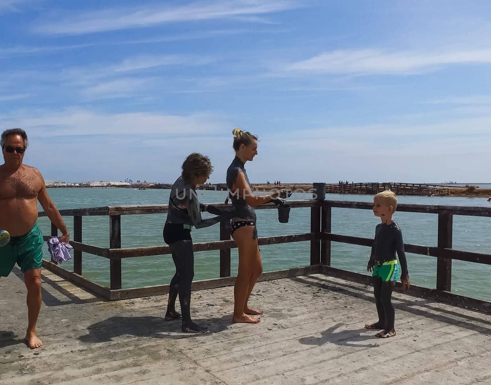 Alicante, Spain - July 24, 2019: People are wiped with mud. Mud baths in Spain.