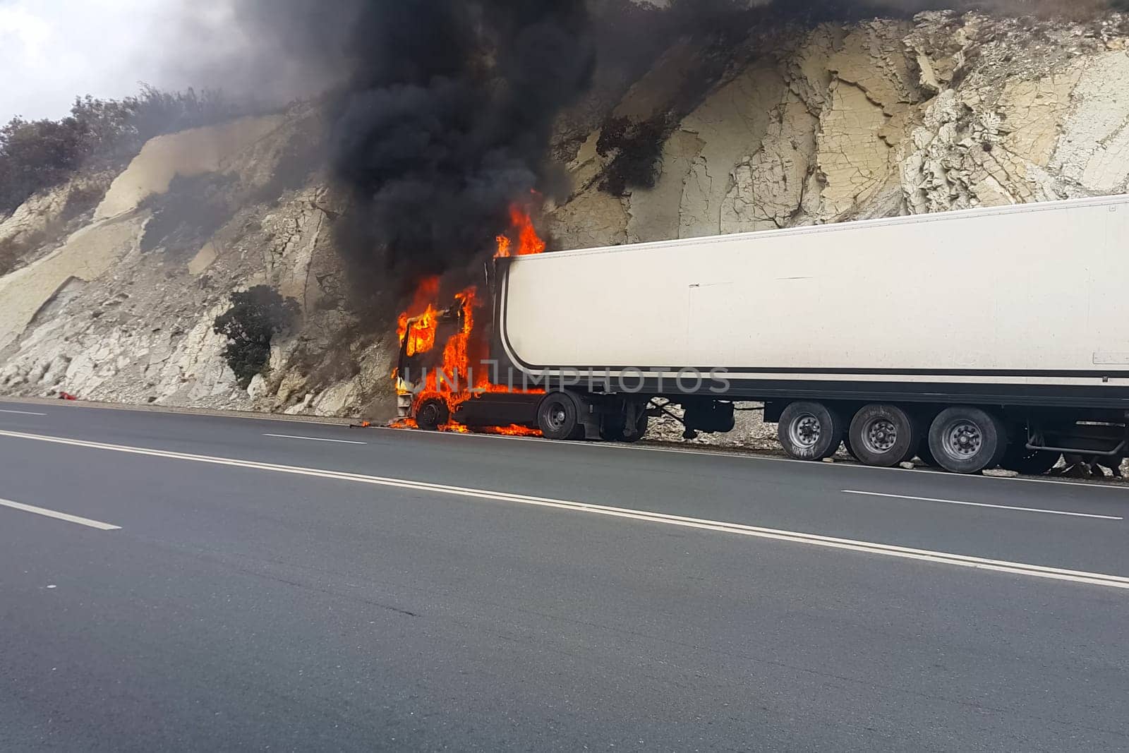 Burning truck on the road. The cab of the truck is on fire.