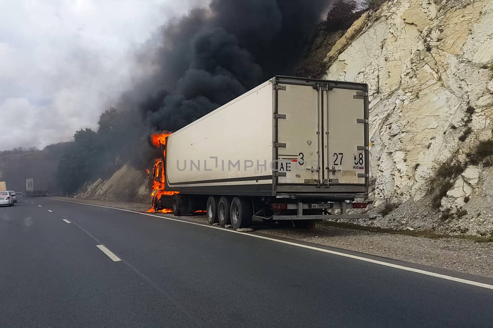 Burning truck on the road. The cab of the truck is on fire.