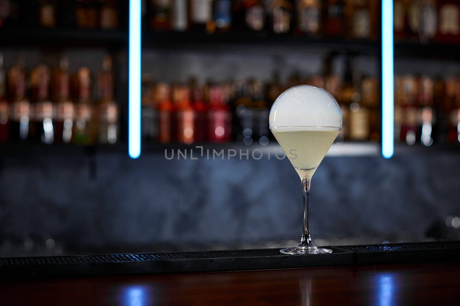 exotic alcoholic cocktail with smoky air bubble at the bar. soft drink on the bar table.