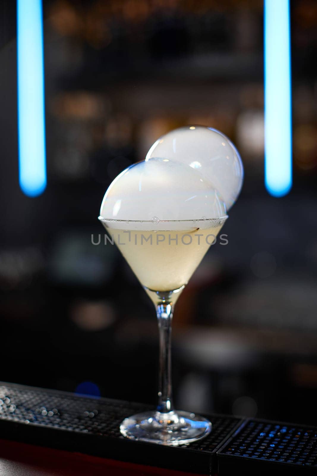exotic alcoholic cocktail with smoky air bubble at the bar. soft drink on the bar table.