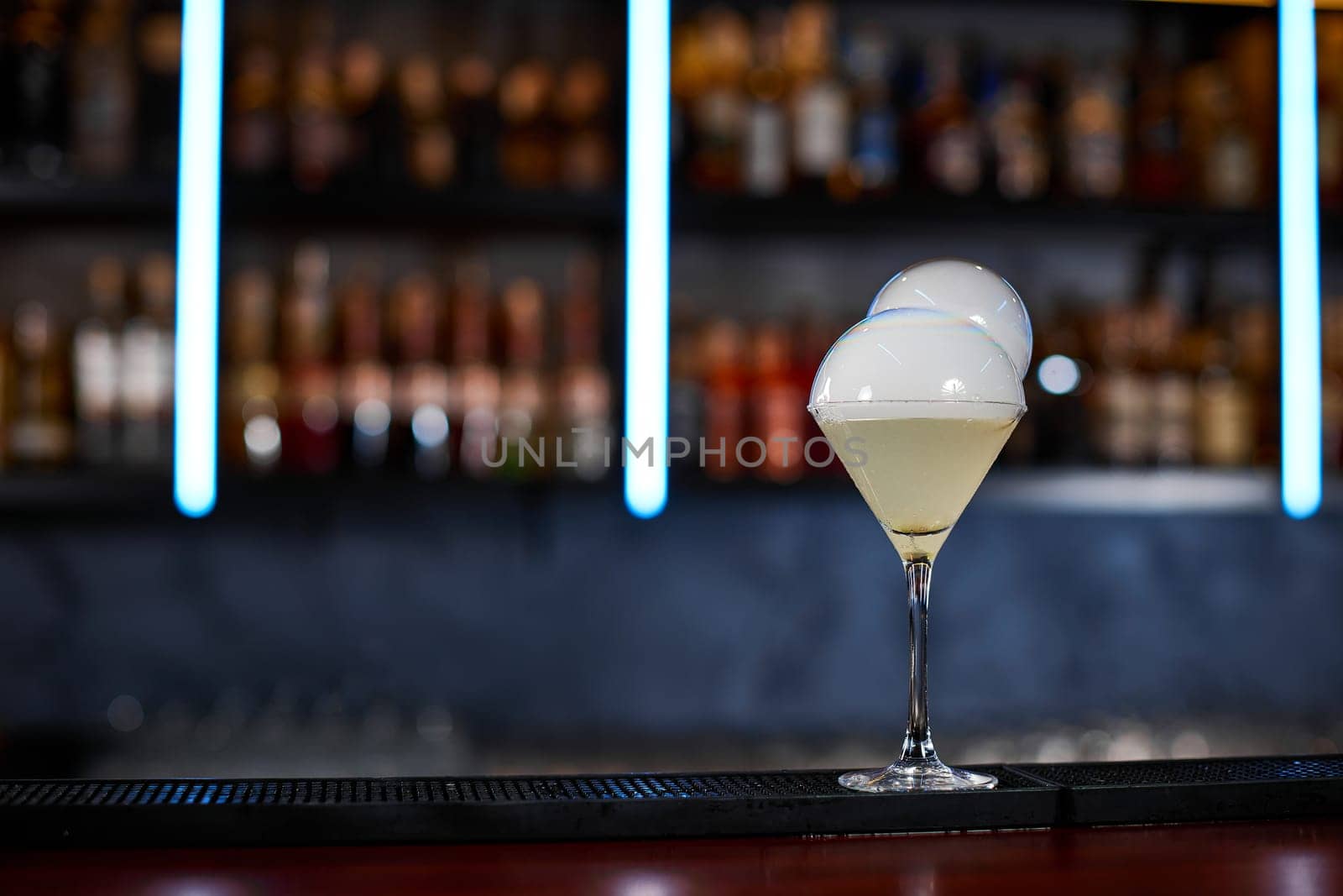 exotic alcoholic cocktail with smoky air bubble at the bar. soft drink on the bar table. copy space