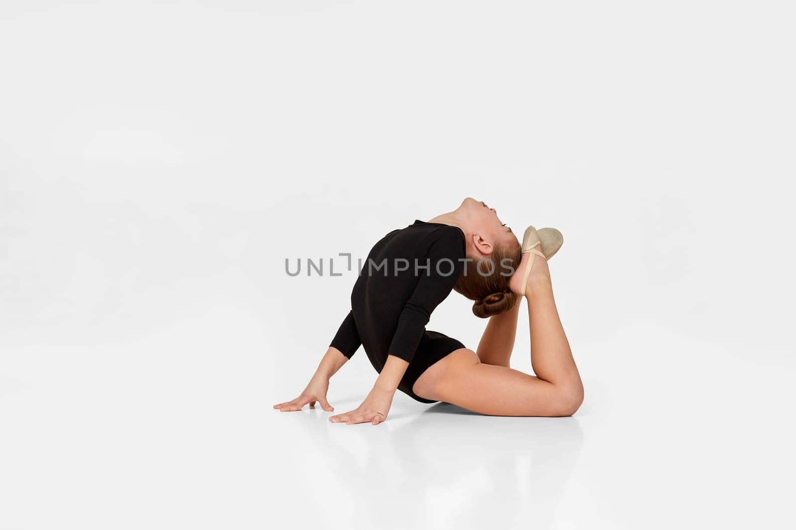young beautiful gymnast girl in black sportswear performs gymnastic poses