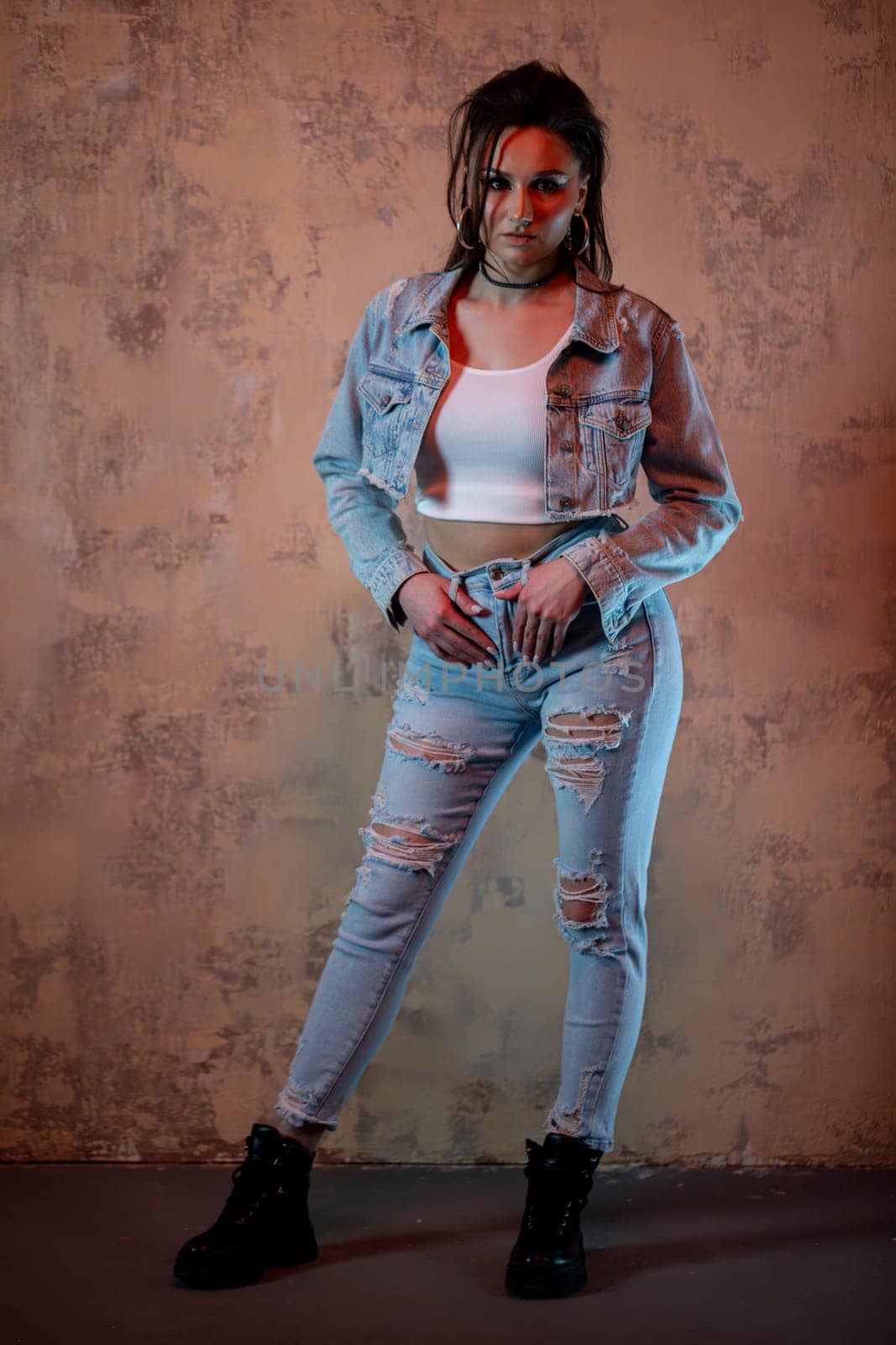 An incredibly stylish young woman strikes a pose in trendy denim outfits, capturing the essence of modern urban fashion