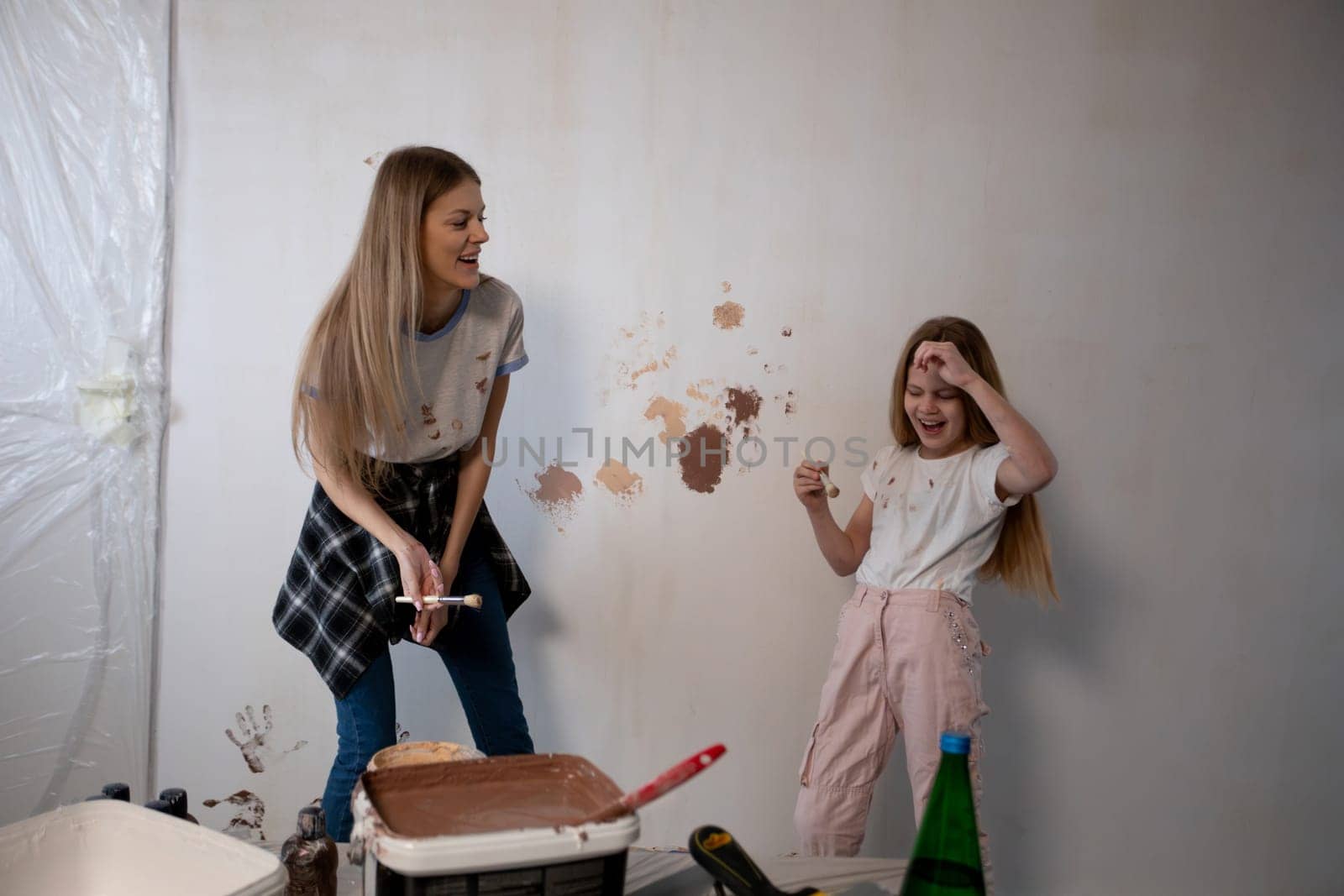 A delightful and enjoyable home painting session shared between a parent and their child, showcasing joy and creativity