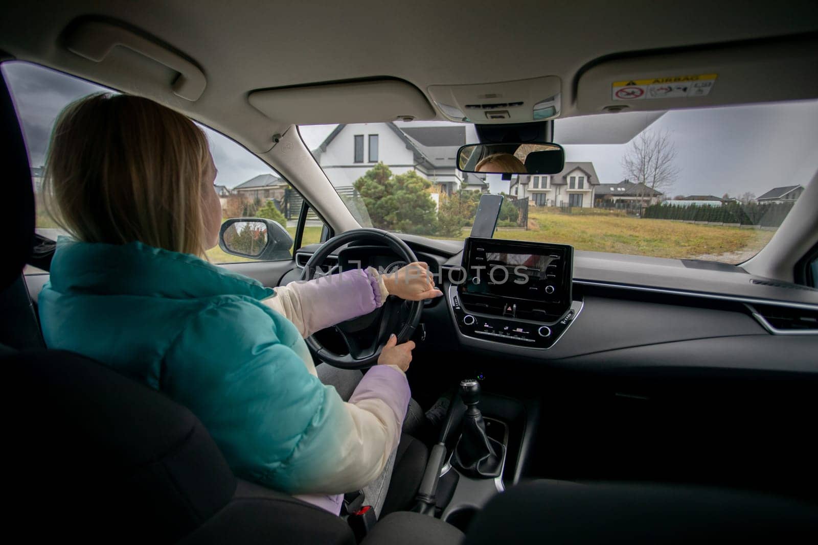 A woman grips the steering wheel, excited for an adventure through the breathtaking scenic countryside