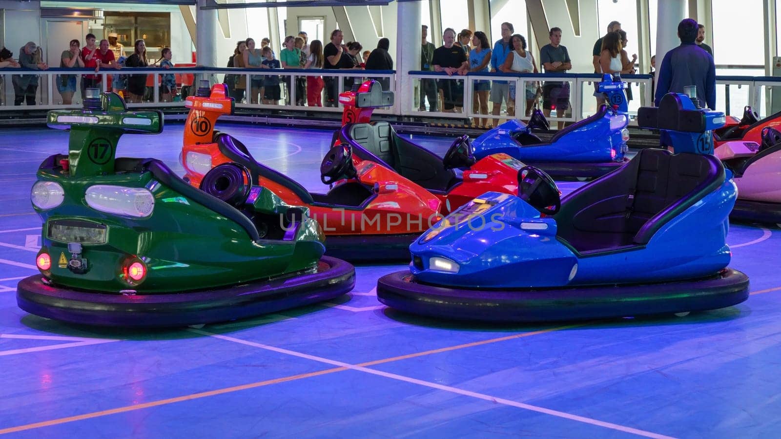 People having fun and bumping into each other with electric bumper cars on a cruise ship. New York NY USA - 09.02.2024.