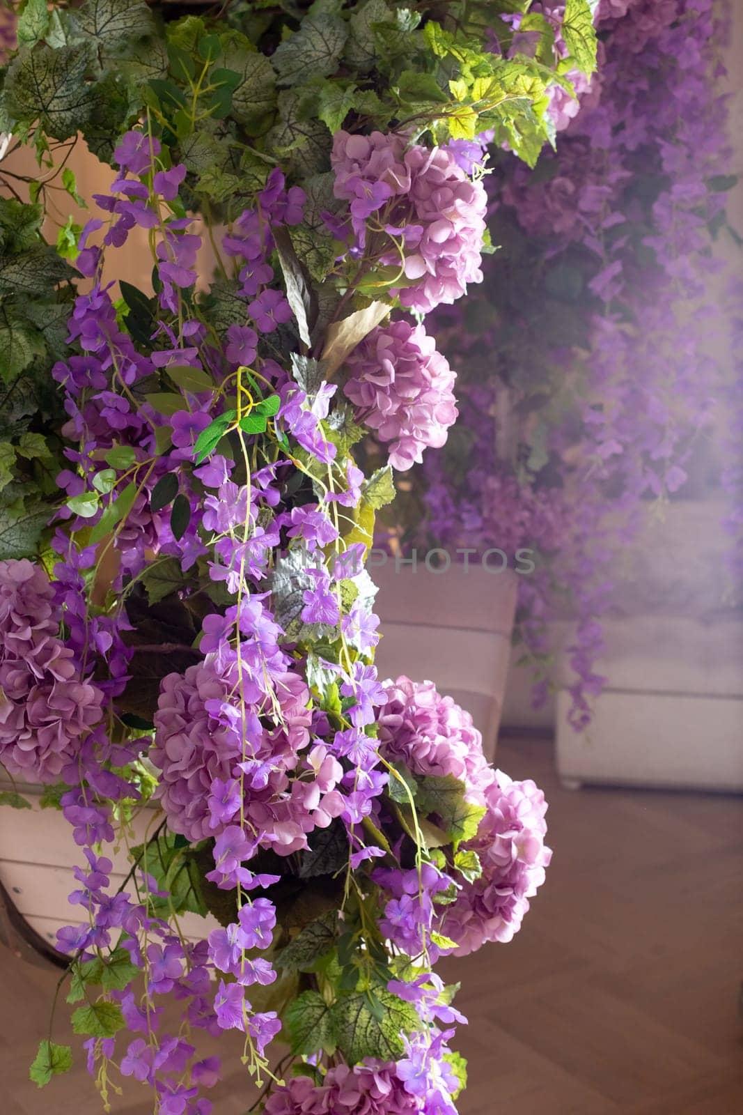 Lavish lilac and purple floral display with lush greenery in soft sunlight.