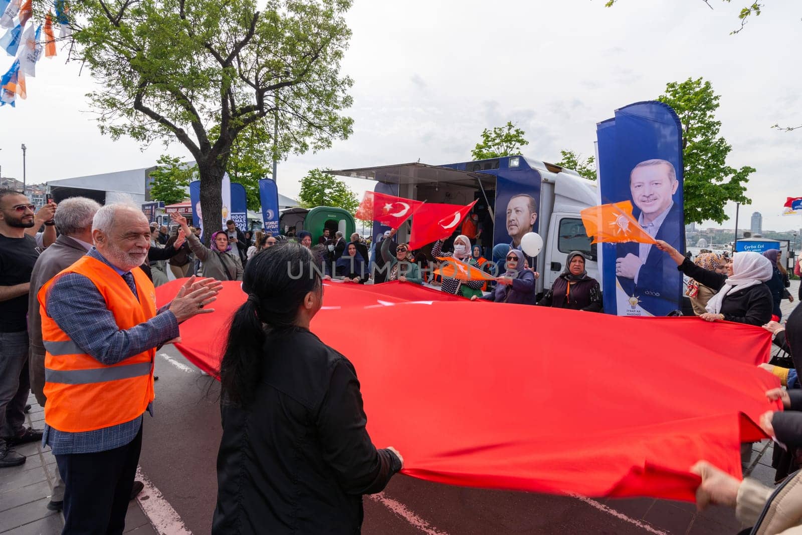 Istanbul, Turkey - May 3 2023: AK Party supporters waving a big Turkish flag in front of AK Party tent in the neighbourhood of Uskudar during 2023 elections