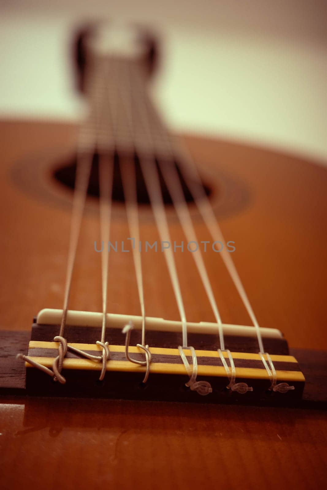 This image showcases a close-up view of guitar spain strings and the bridge, highlighting the intricate craftsmanship and materials that contribute to musical sound.