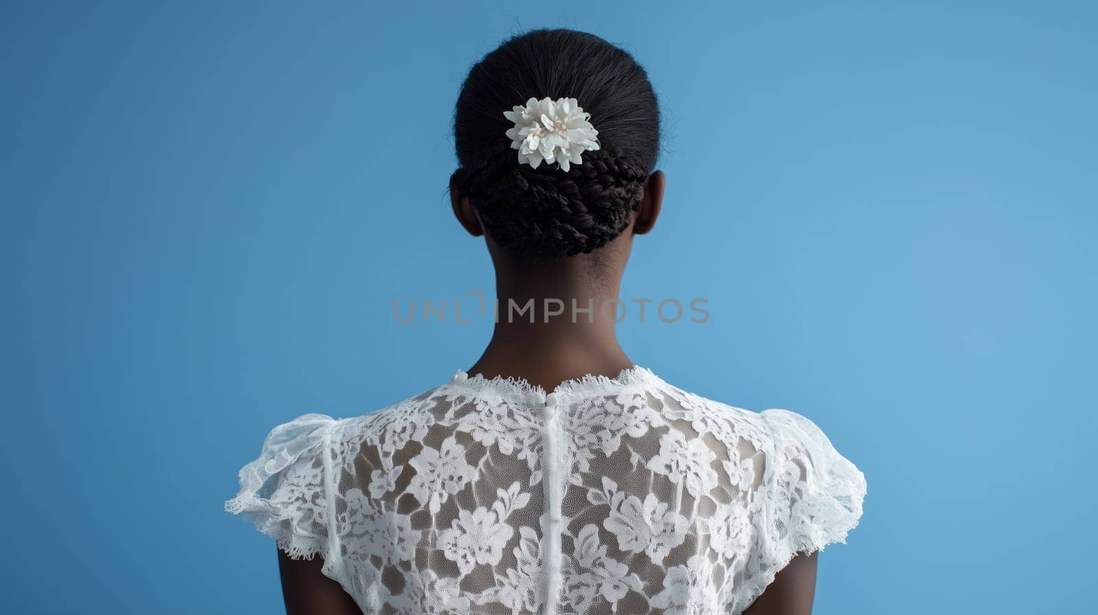 Back view, close-up elegant black young bride woman standing in lace white dress on blue studio background