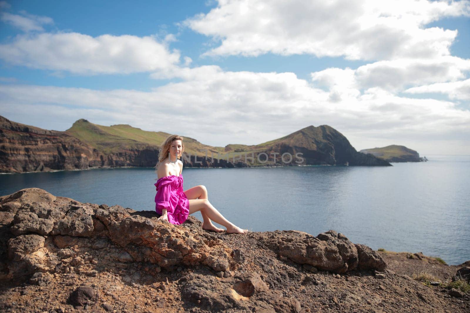 Fashion blogger enjoying breathtaking views of the atlantic ocean from rocky cliffs in madeira