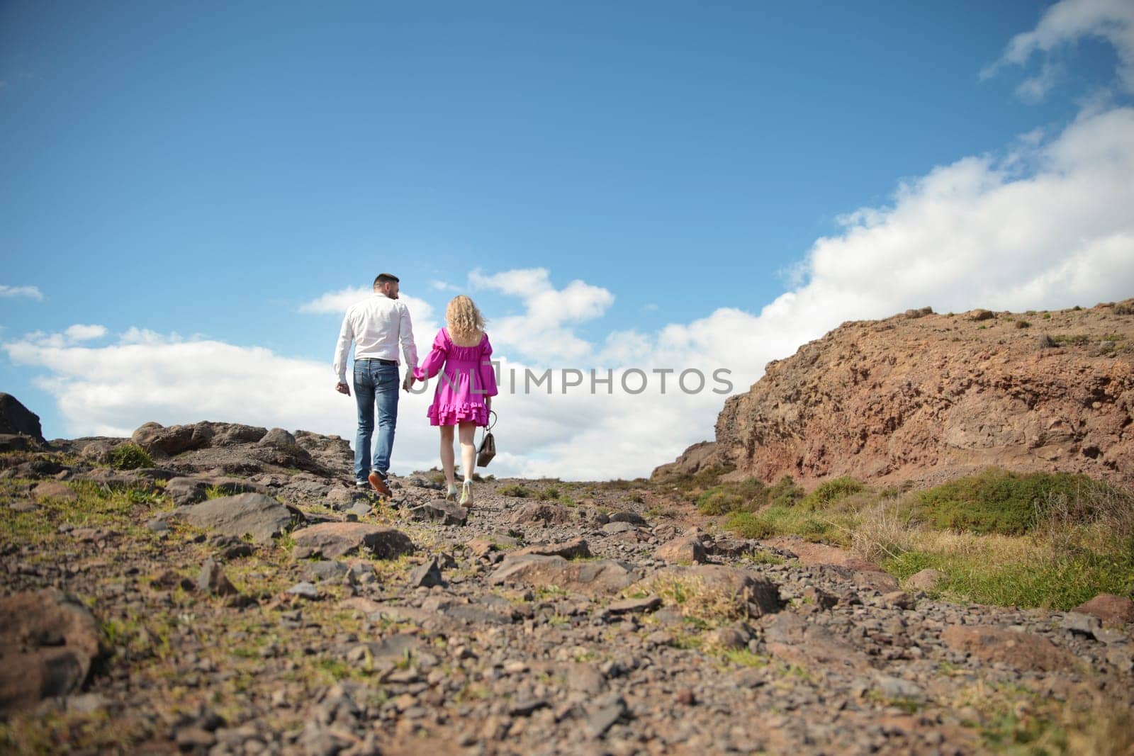 Couple walking on rocky path holding hands in madeira island, portugal