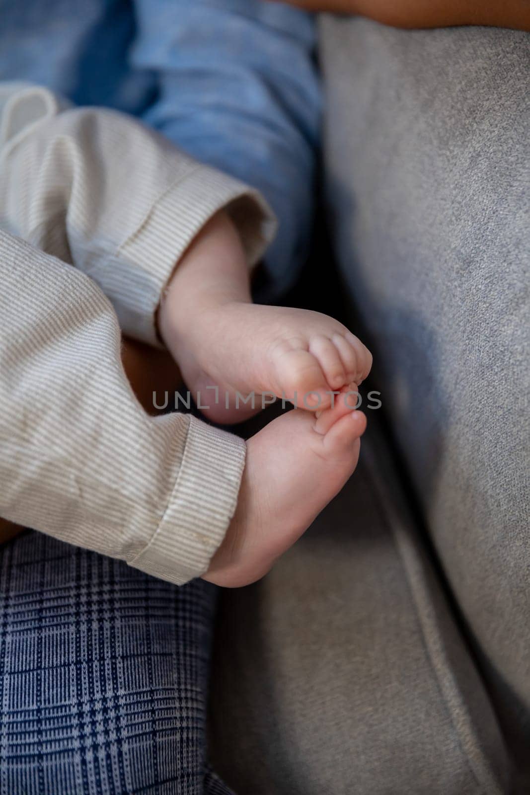 Its a touching moment when a babys tiny hands and adorable feet rest comfortably together on a cozy surface