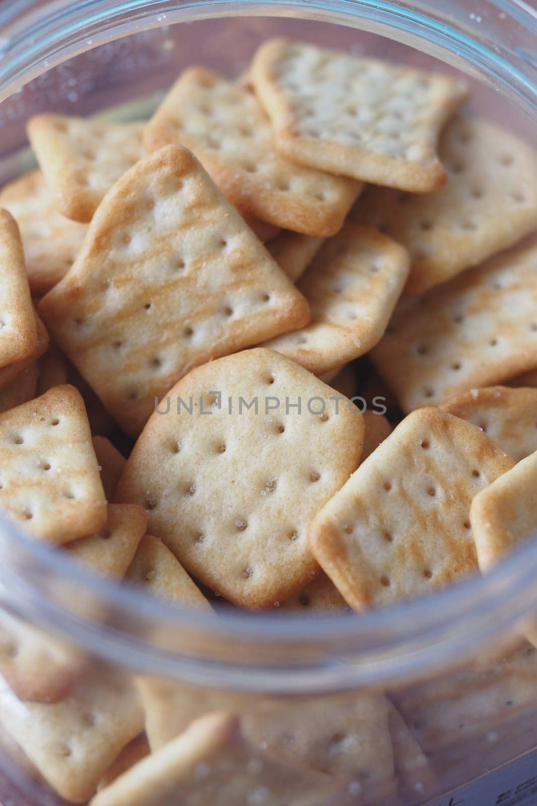 Close-up of assorted square and rectangular crackers in a container.