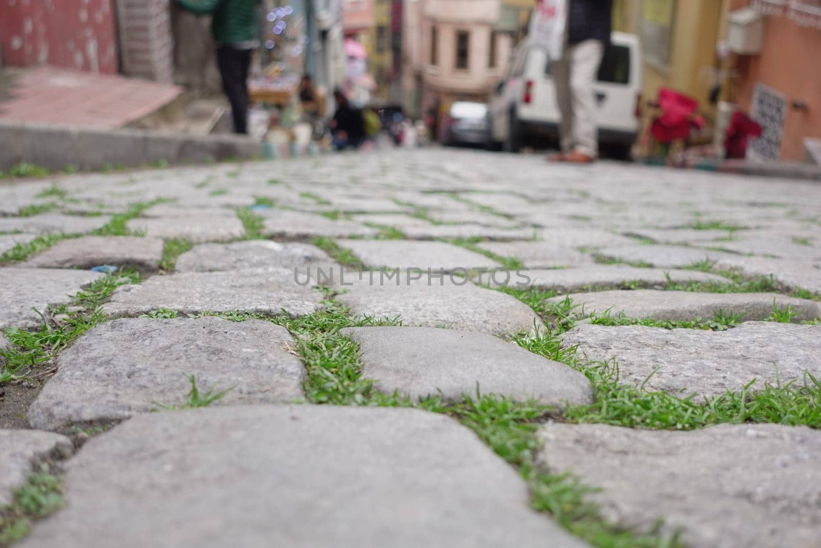 Weathered cobblestones line a vibrant street in an urban area.