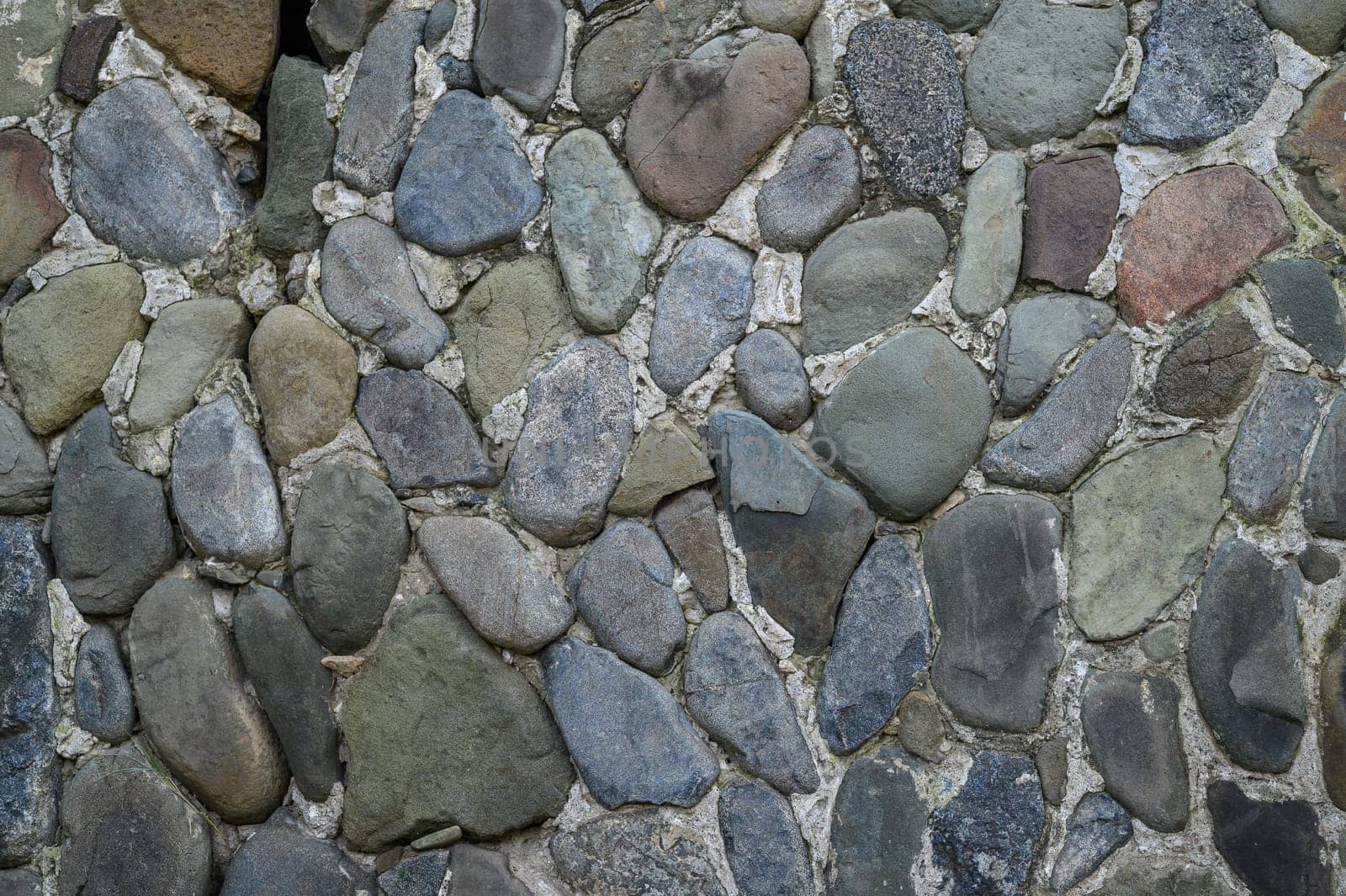 Smooth and rough stones blend beautifully on this wall, enhancing the peaceful atmosphere of the garden at twilight.