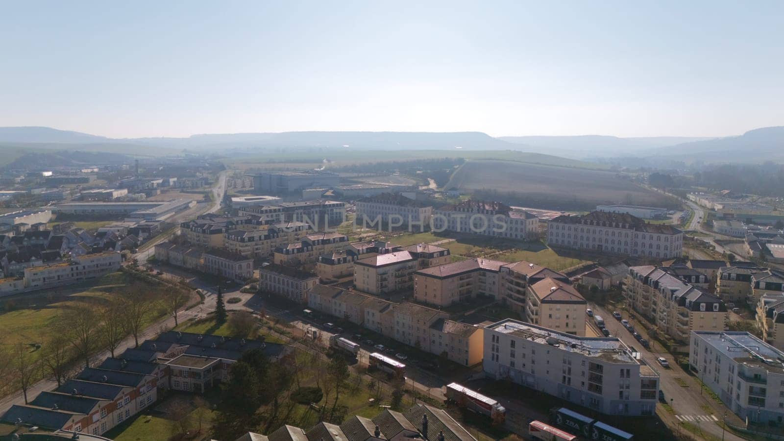 Aerial view of a residential district in Epernay, France, surrounded by open farmlands, distant hills, and modern urban infrastructure.
