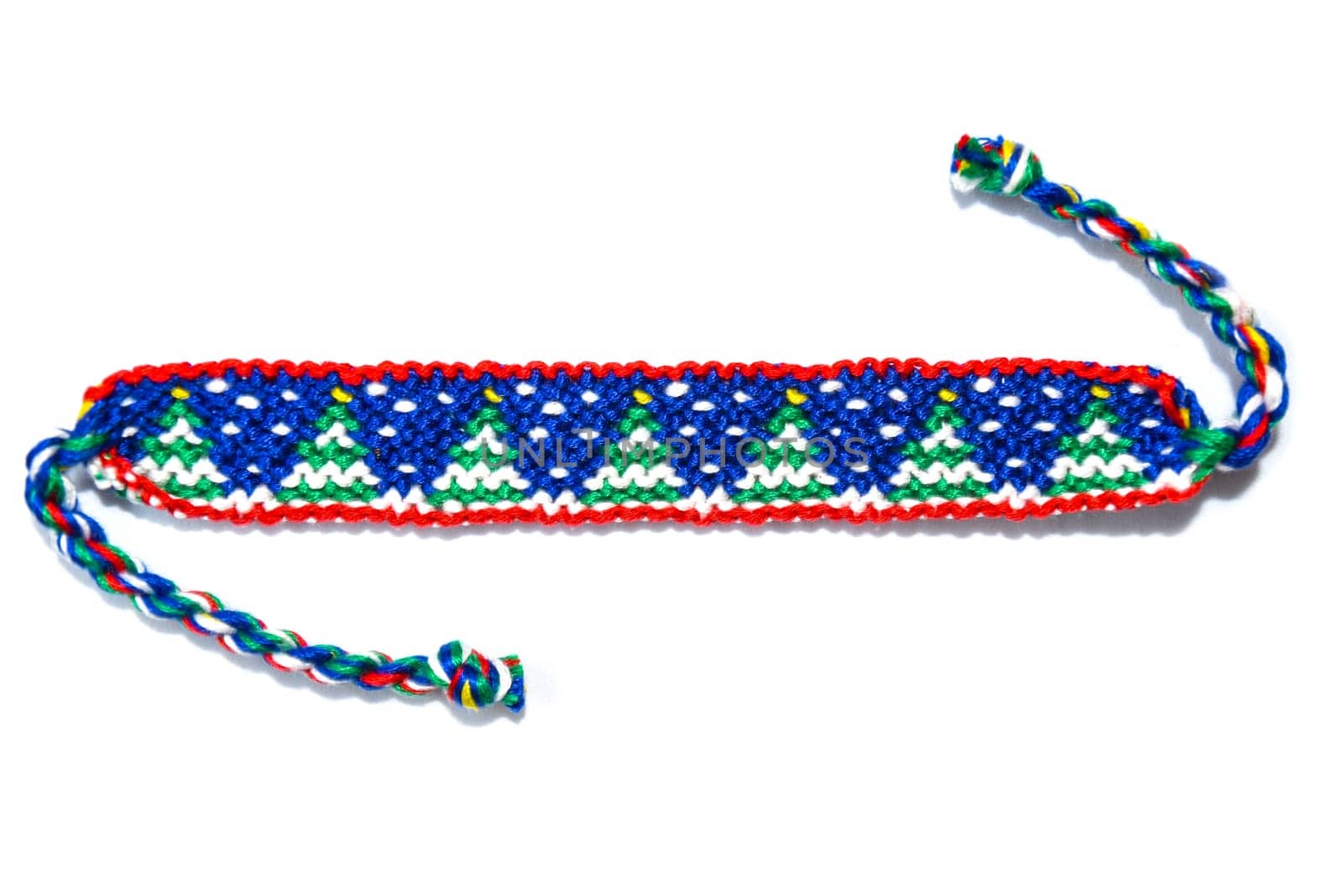 Woven friendship bracelet with Christmas pattern. Handmade of thread, isolated on white background. New Year DIY gift idea