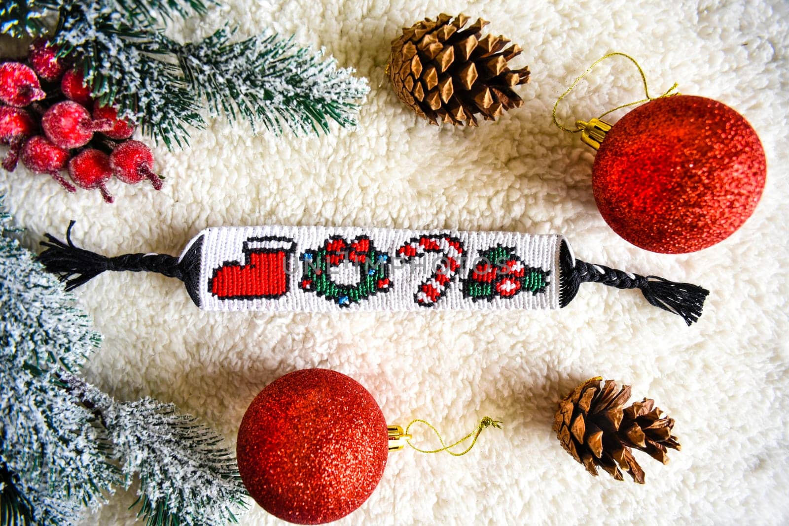 Woven friendship bracelet with pattern Christmas berry, lollipop, wreath and santas boot. DIY New Year gift idea