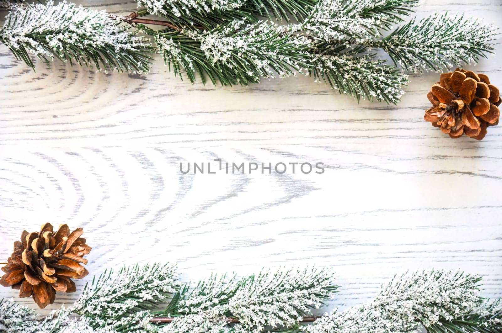 Wooden Christmas background frame with snowy fir tree branches and cones. new year design, copy space
