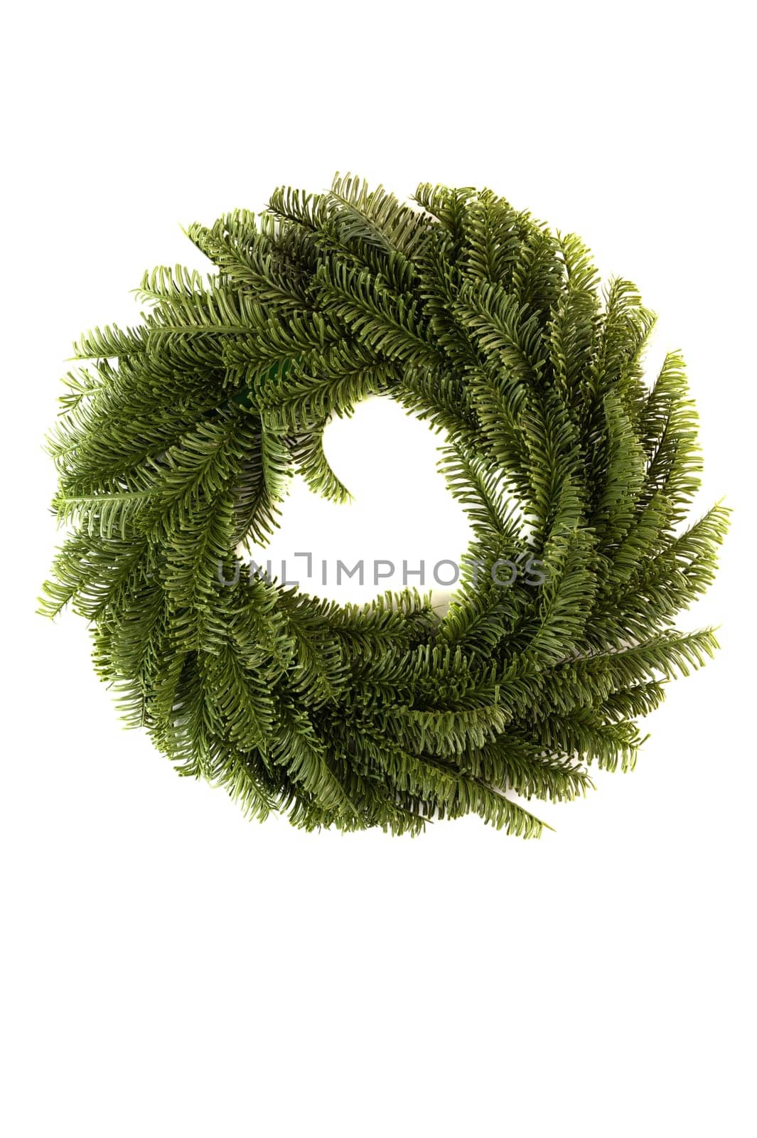 Christmas wreath made of artificial spruce branches for home decoration, on a white background