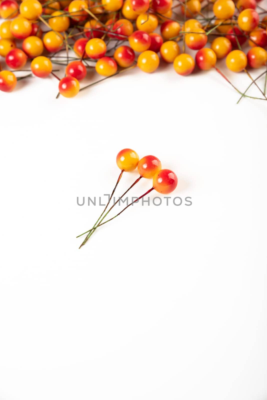 Artificial berries on a wire for needlework and decoration of gifts, wreaths on white background