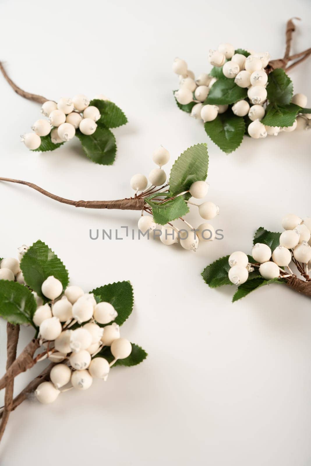 Artificial berries on a wire for needlework and decoration of gifts, wreaths on white background