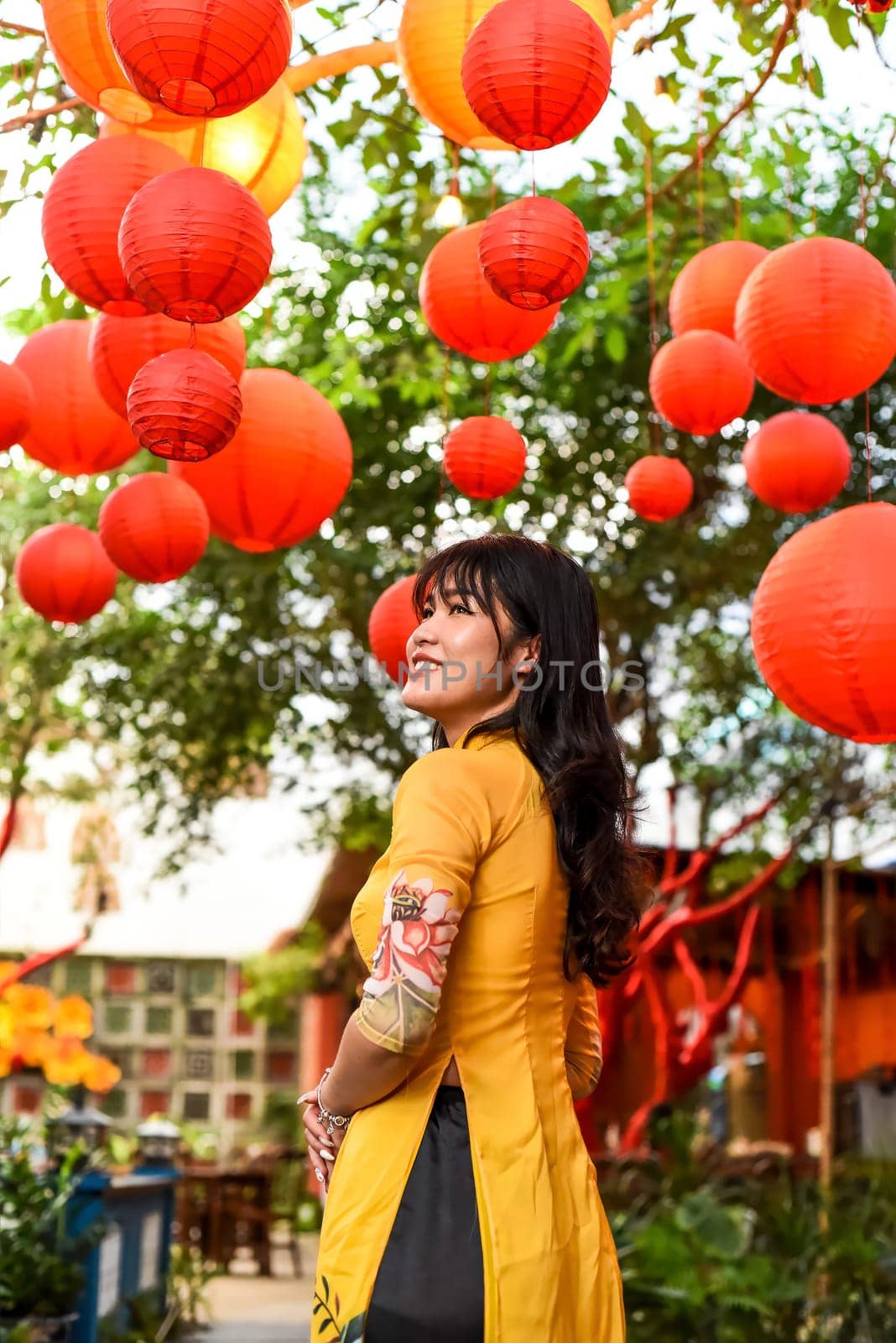 Beautiful Vietnamese woman in traditional vietnamese dress near red lanterns in Tet  Lunar New YearBeautiful Vietnamese woman in traditional vietnamese dress near red lanterns in Tet  Lunar New Year