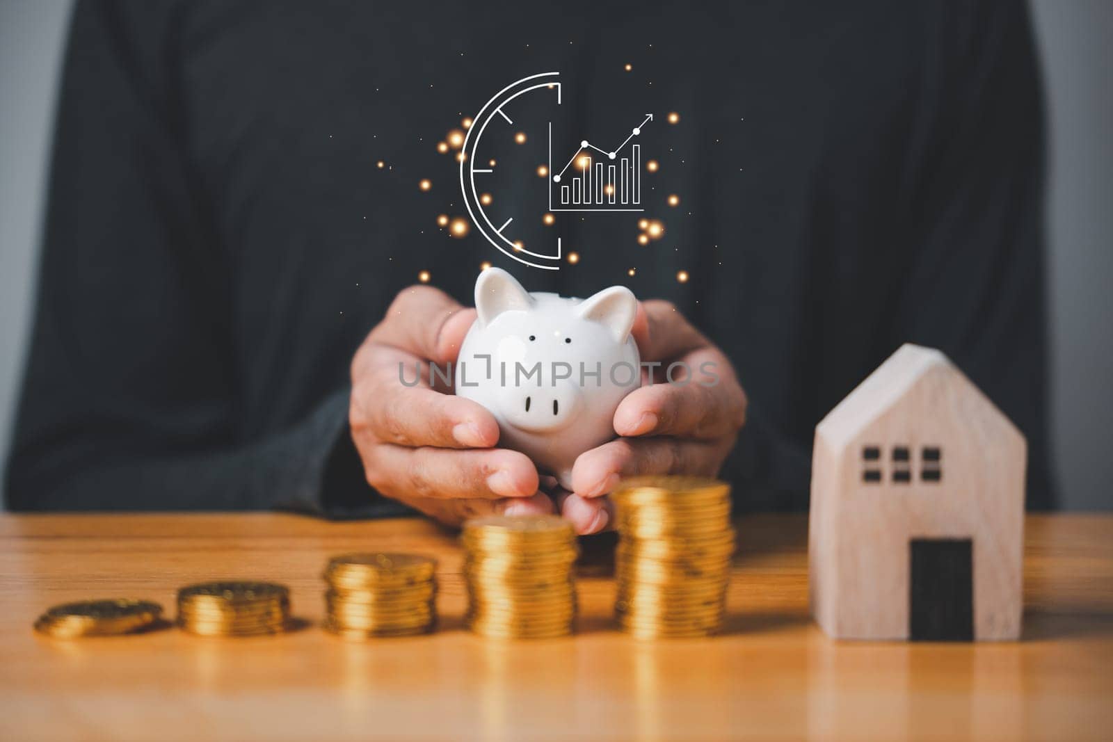 A hand holding a piggy bank with coins stacked beside it, symbolizing idea of saving and investing money. The concept of financial planning and wealth management is important for economic stability.