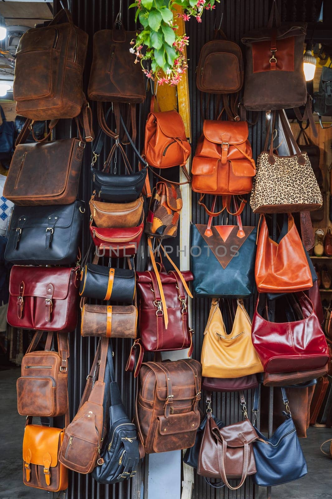leather bags, belts and accessories on the counter in a shop at a street market in Hoi An in Vietnam in Asia