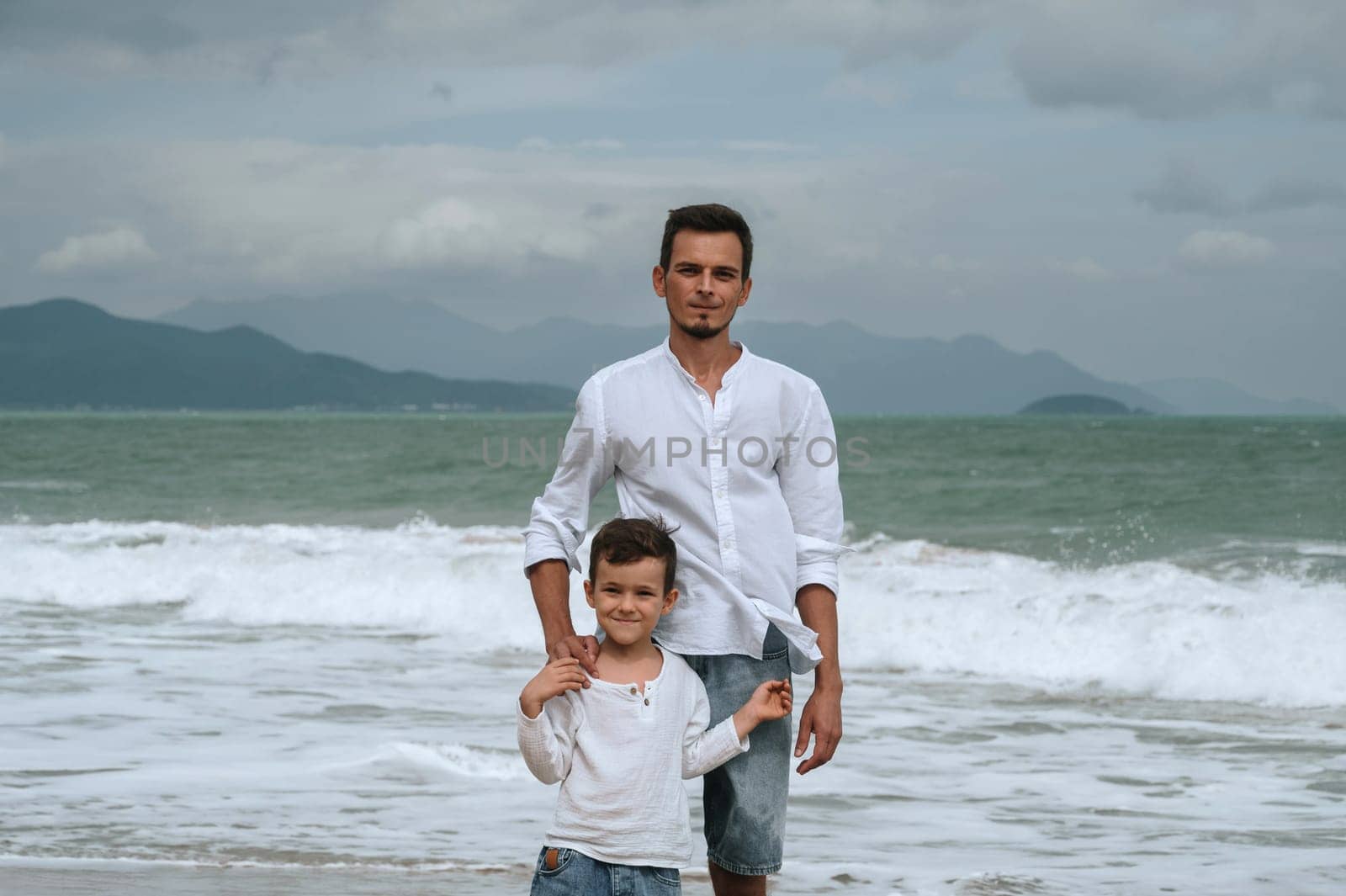 happy father dad with a child boy son on the beach by the sea on a summer vacation