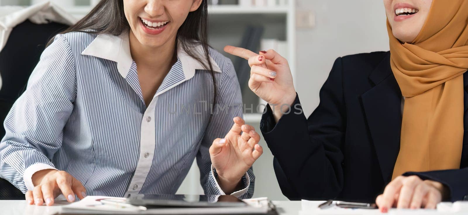 Two engaged financial professionals share ideas and strategies, highlighting collaboration and diversity in a vibrant office space.
