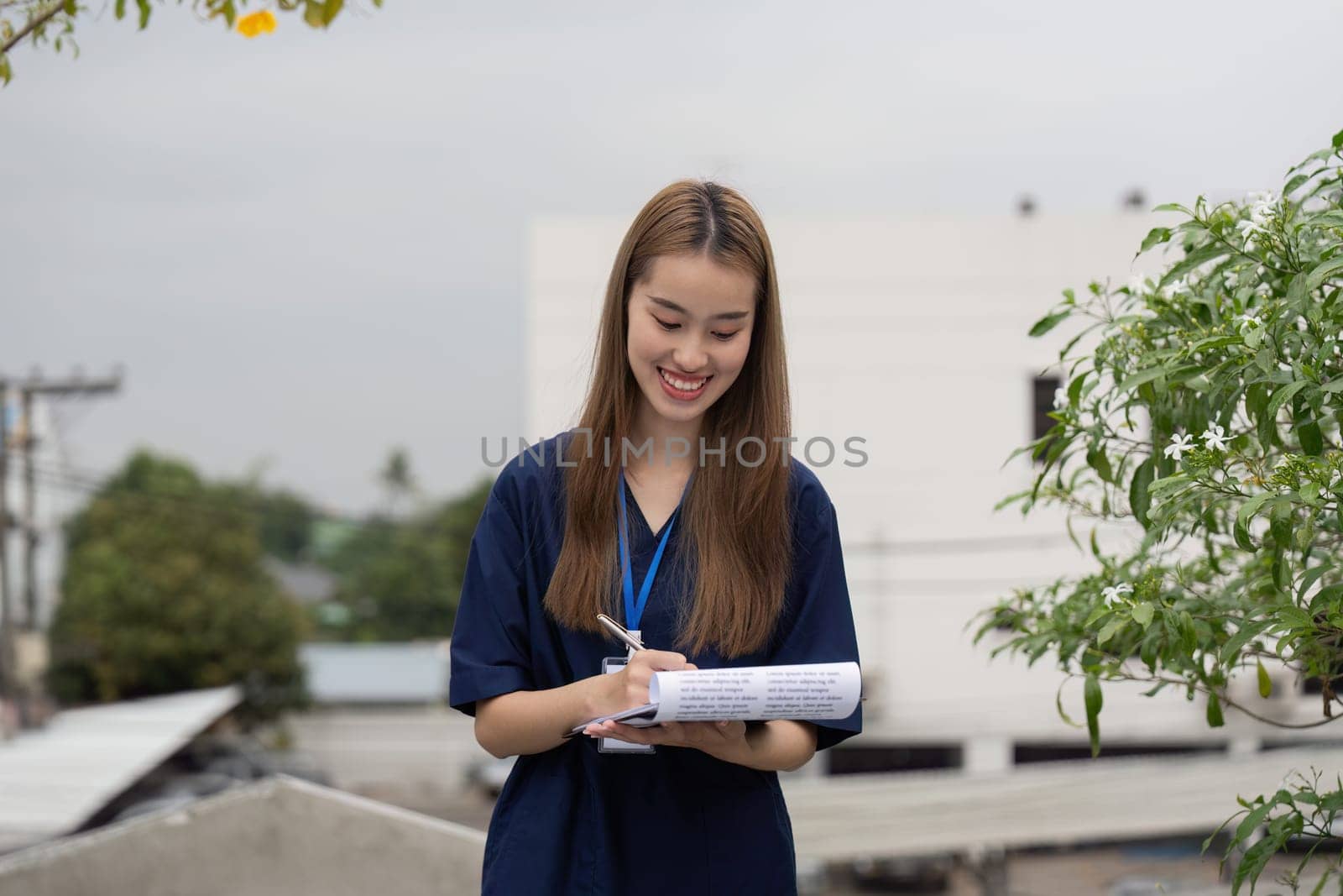 A joyful female physician enjoys her break outdoors, writing notes and sipping coffee, representing a balanced healthcare lifestyle.