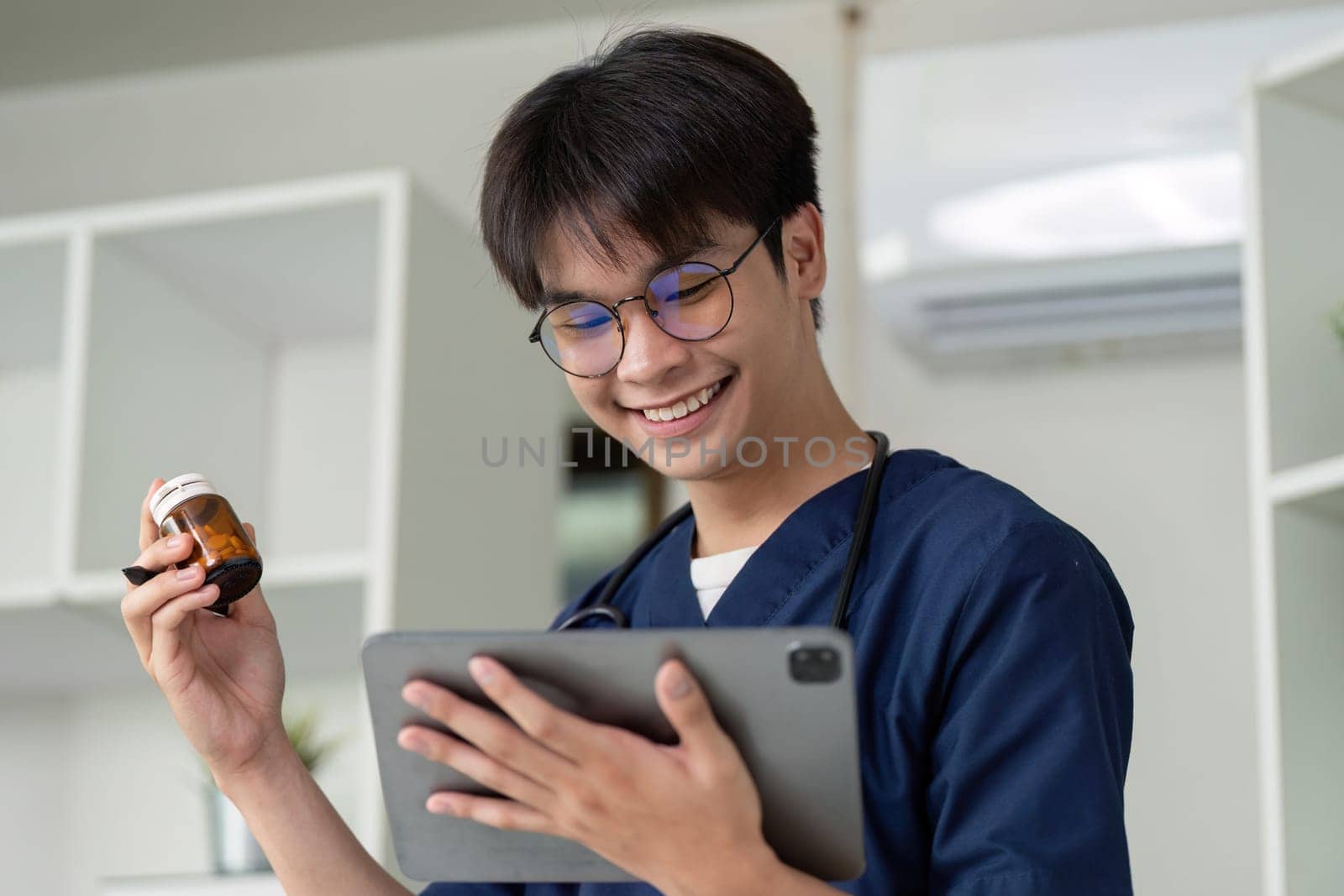A cheerful medical student holds a medication bottle and a tablet, showcasing the enthusiasm for learning in healthcare.