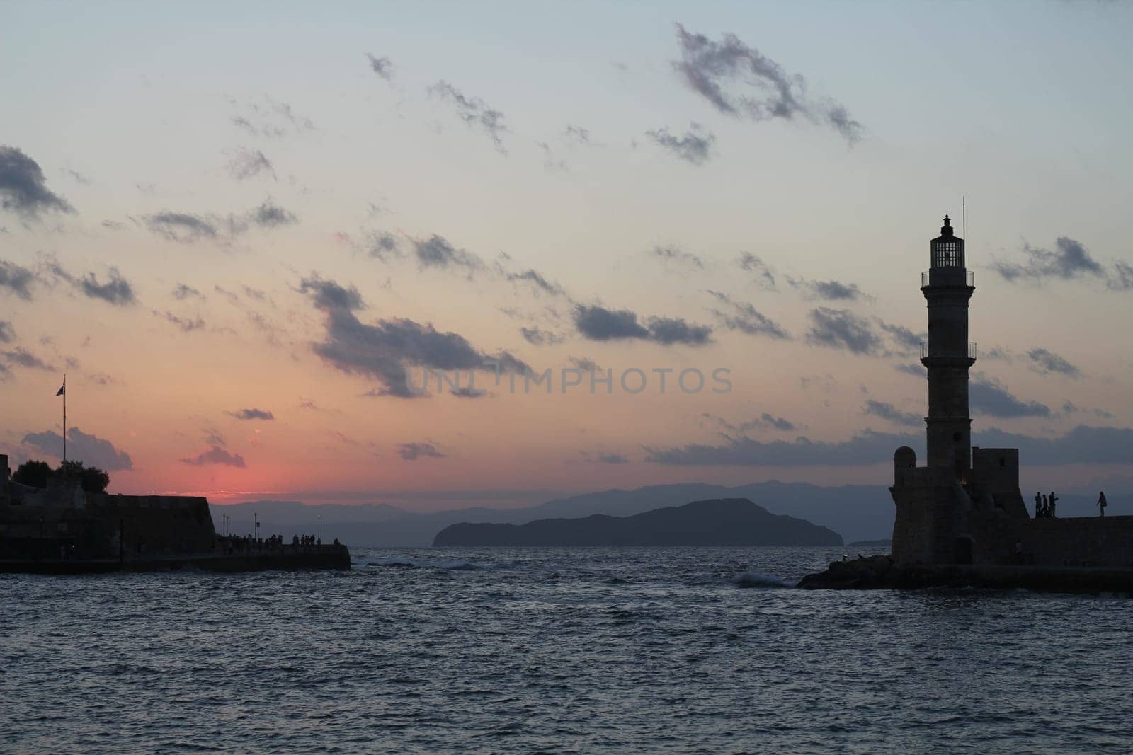 Lighthouse in old harbour of Chania at dawn Crete Greece at sunset