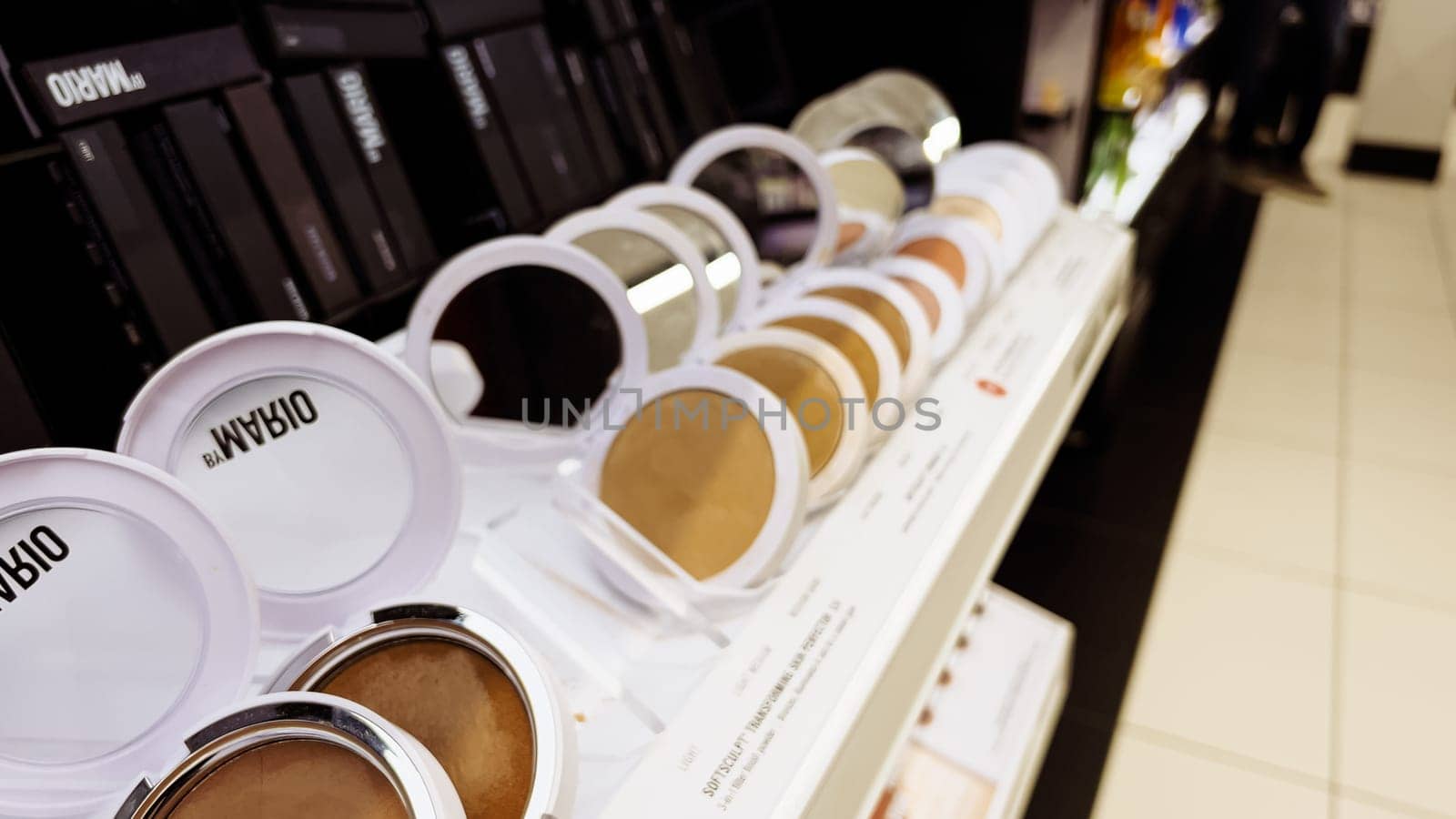 Denver, Colorado, USA-December 31, 2023-Beauty products are displayed with sophistication, featuring shimmering blush palettes, elegant lipsticks, and sleek foundations, reflecting luxury in the store mirrors.