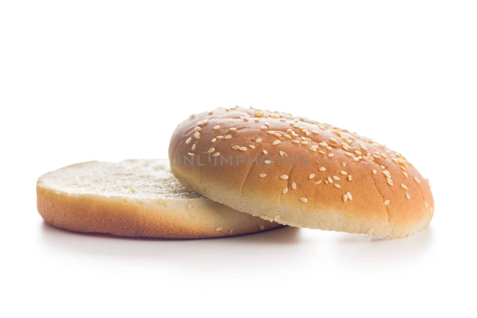 Empty burger bun with sesame seeds isolated on a white background.