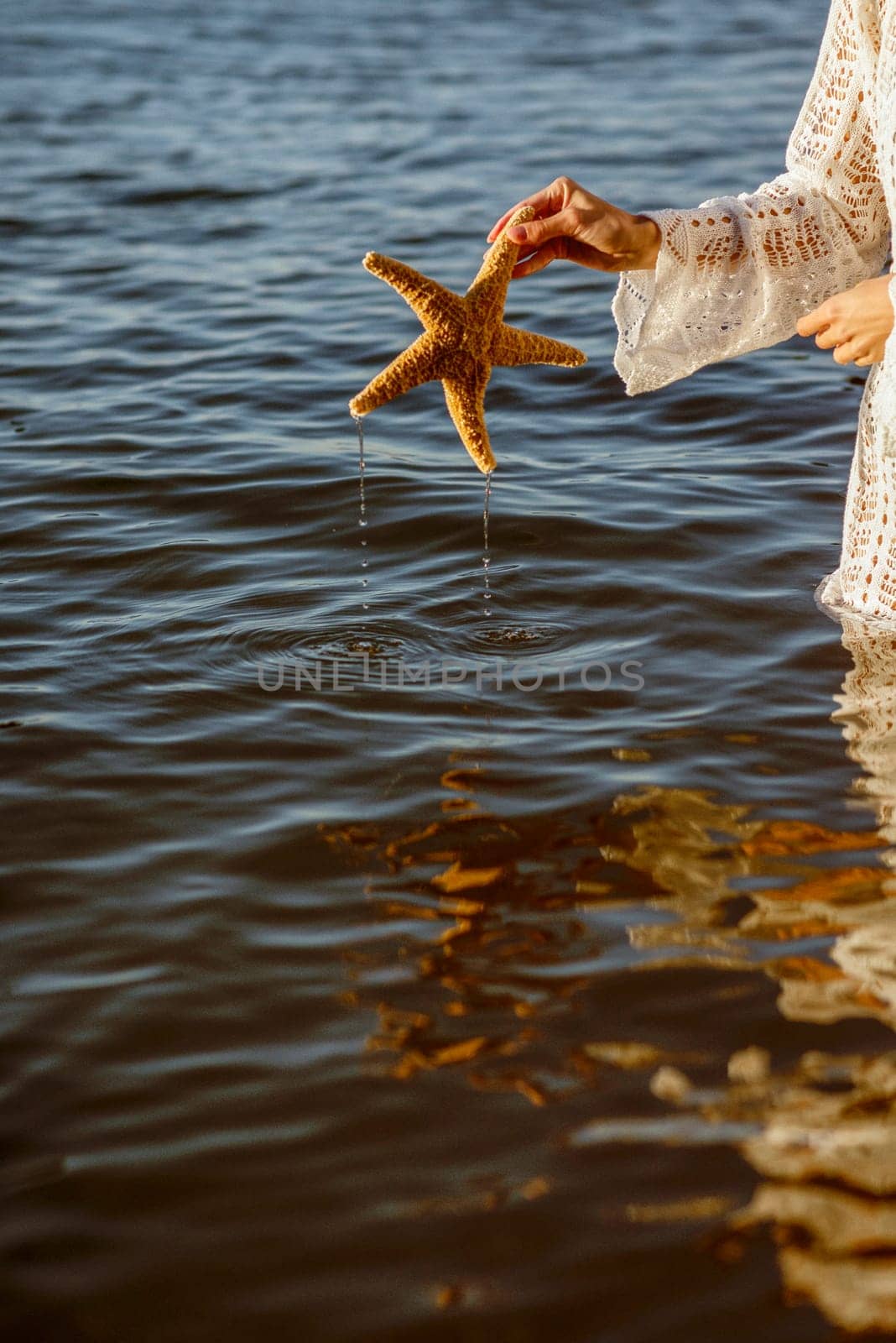 Hand holding starfish with beautiful tropical summer sand beach island, relaxing vacation summer blue sea concept. High quality photo