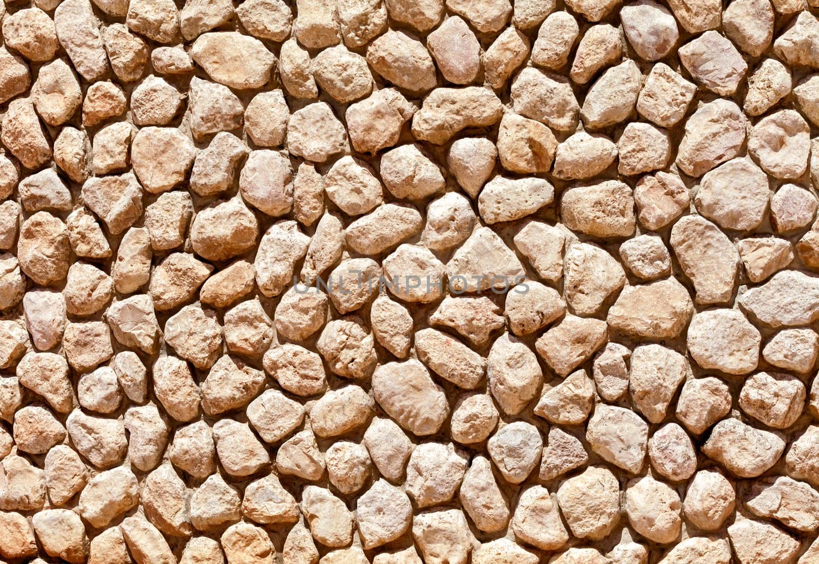 Wall made of cobblestones, close up, for background or texture