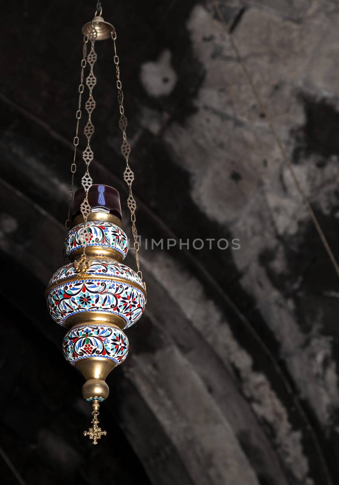 This is a beautifully designed hanging lantern that features intricate patterns along with rich and vibrant colors