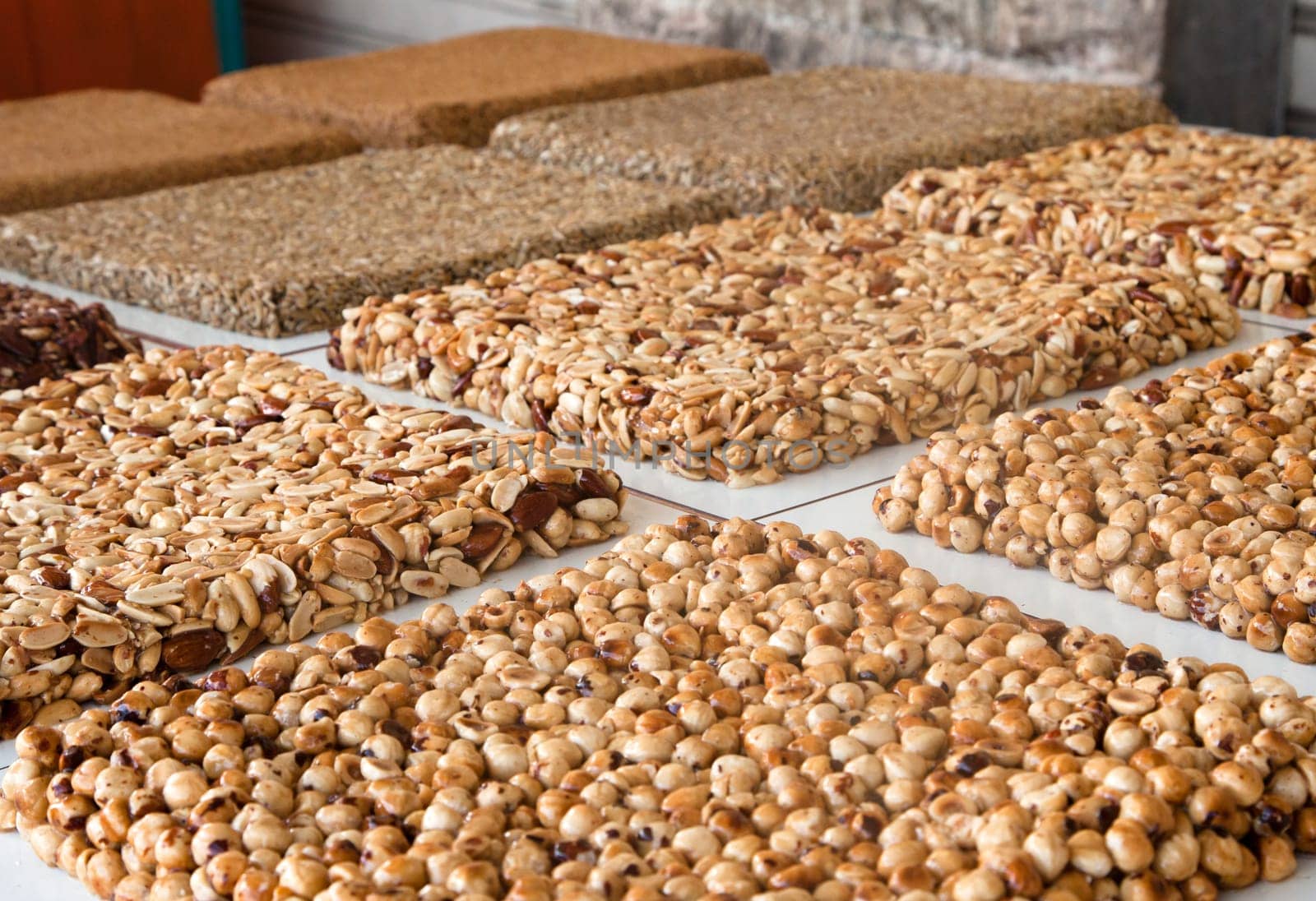 Sherbet with nuts on counter at summer local food market - close up view. Dessert, culinary, turkish sweet food, oriental and confectionery concept