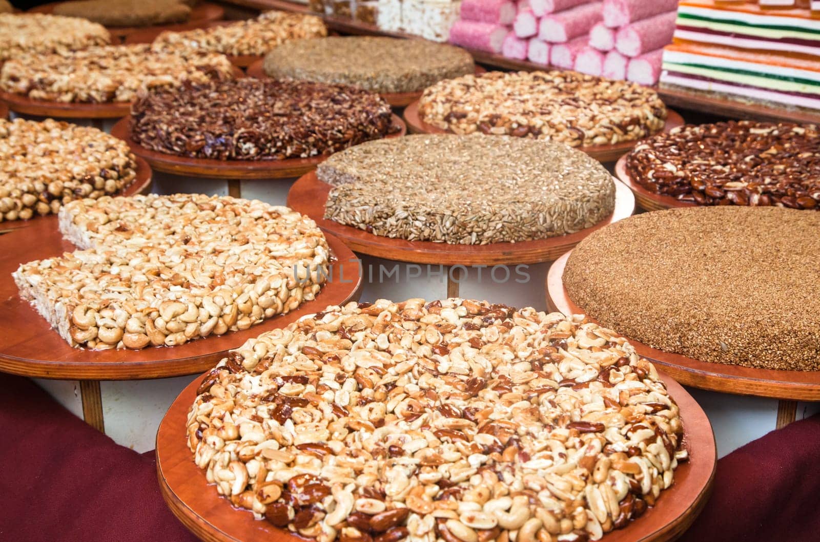Sherbet with nuts on counter at summer local food market - close up view. Dessert, culinary, turkish sweet food, oriental and confectionery concept