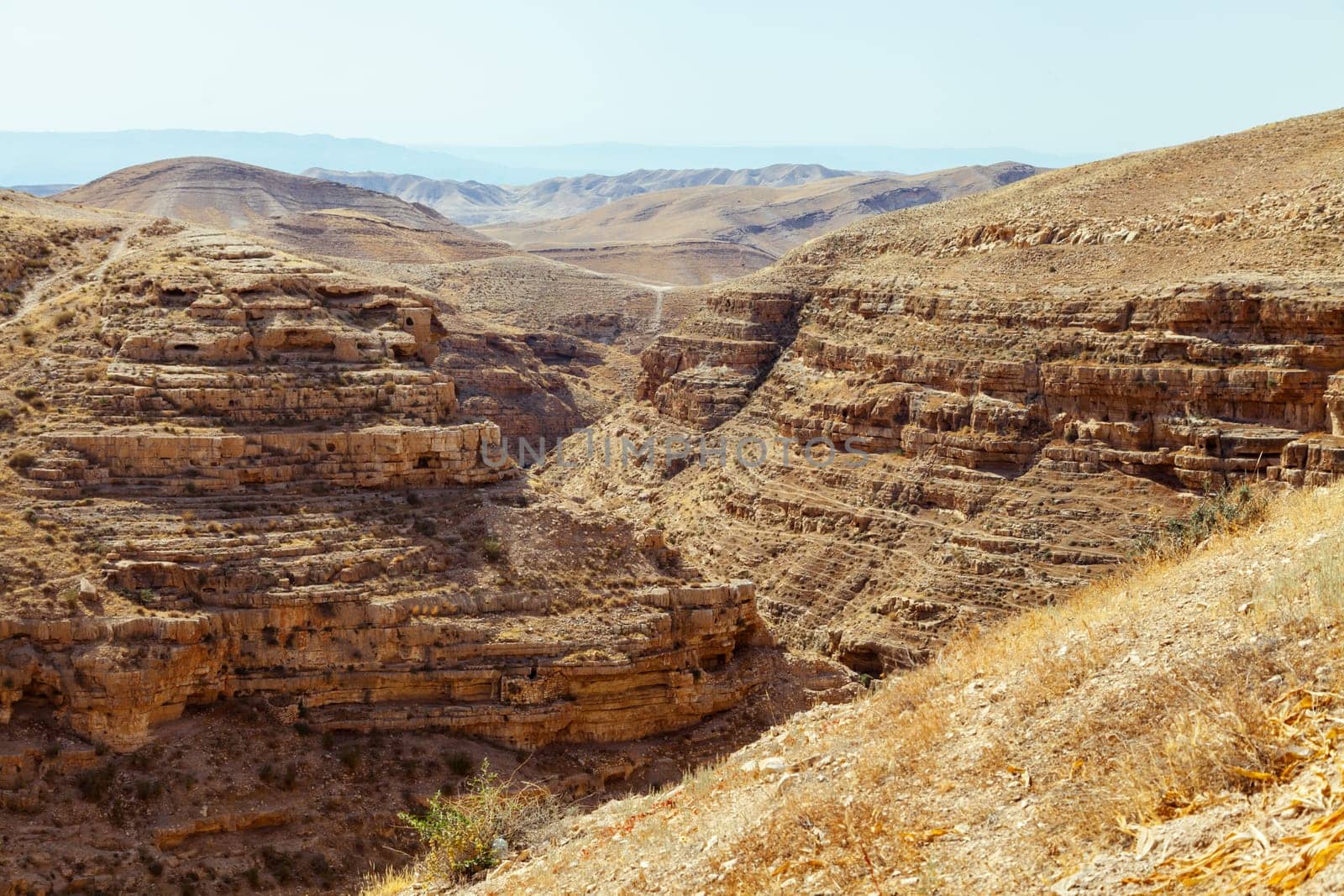 A breathtaking and stunning view of a vast desert canyon showcasing beautifully layered rock formations and dry terrain