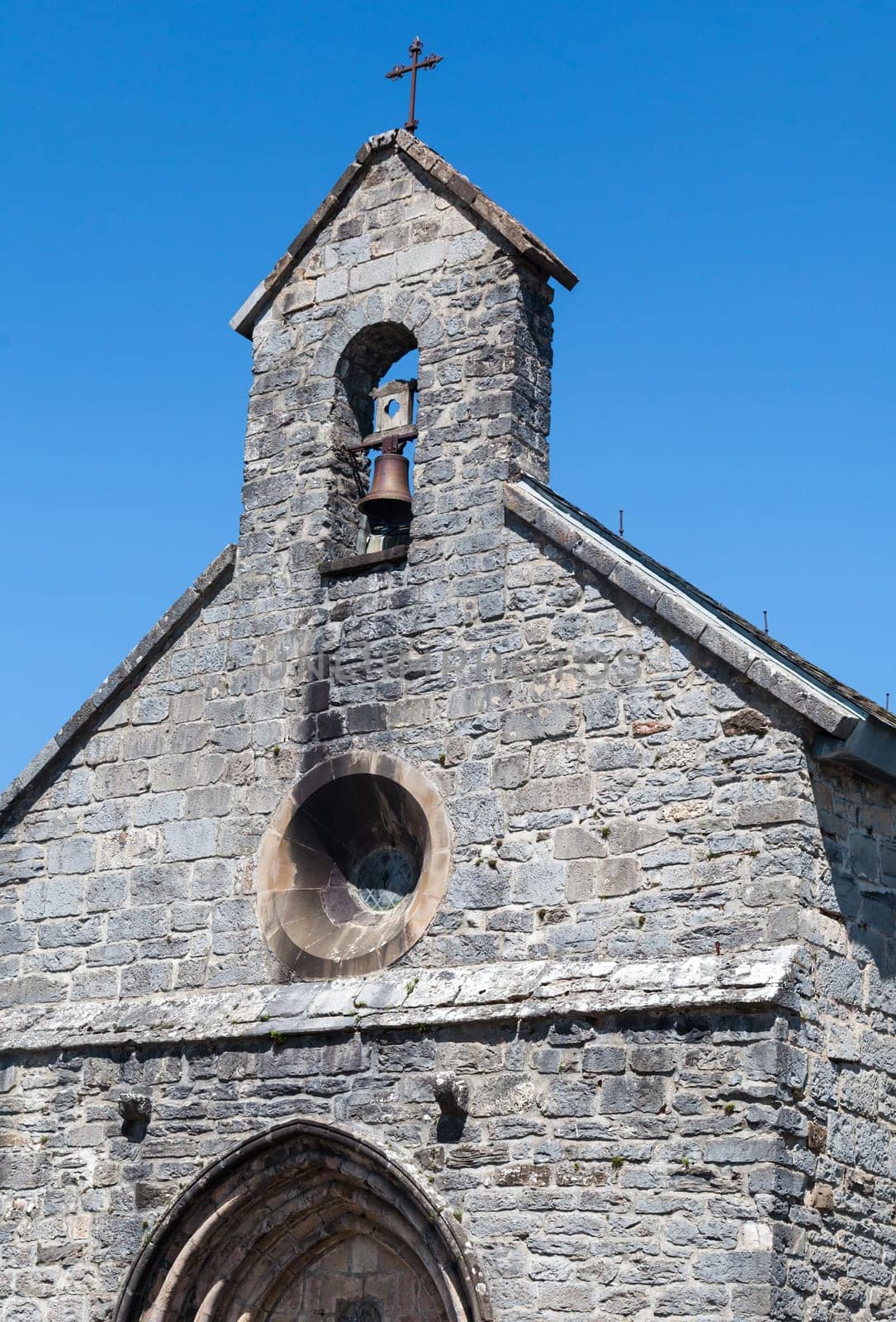 In the French Pyrenees, a charming stone chapel softly chimed, welcoming weary travelers on the Camino de Santiago.