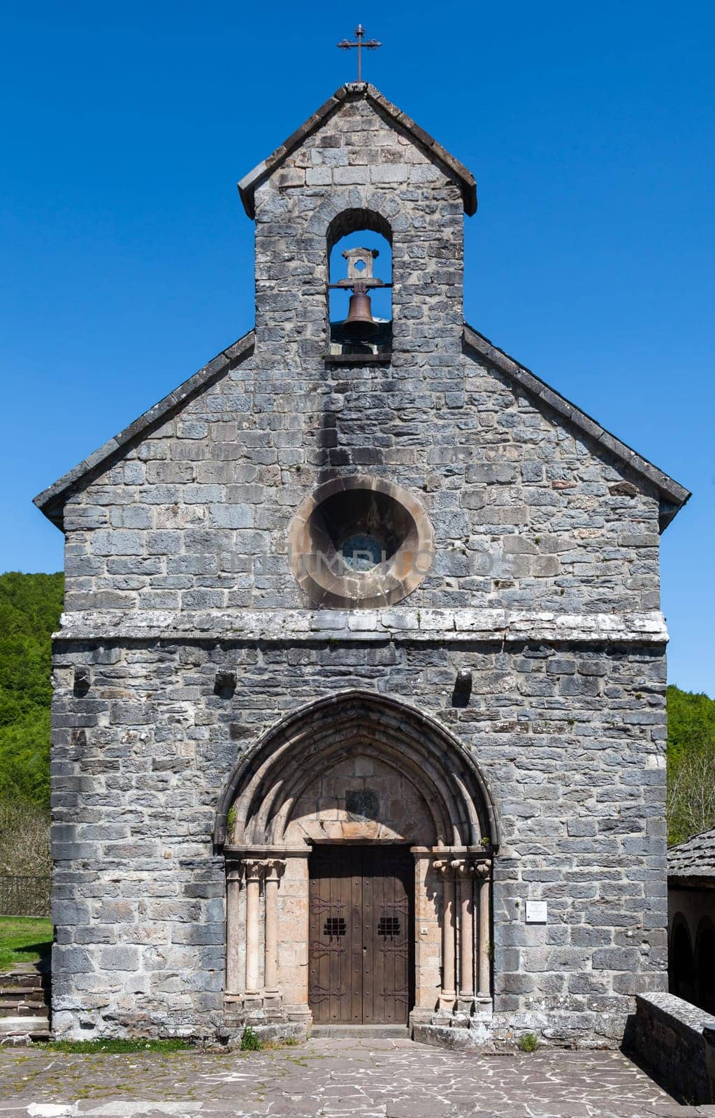 In the French Pyrenees, a charming stone chapel softly chimed, welcoming weary travelers on the Camino de Santiago.